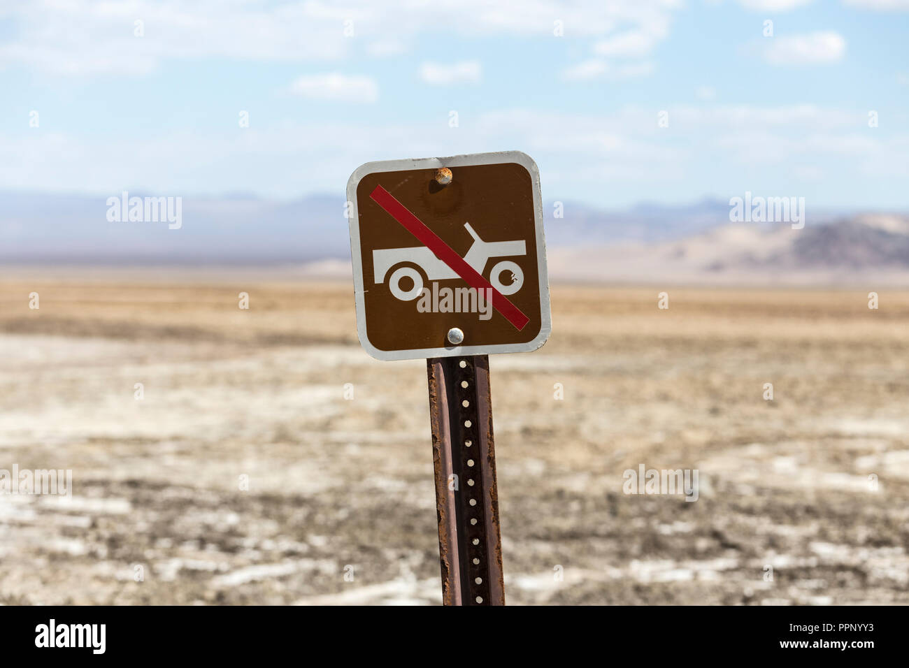Old no off road driving sign with Mojave desert dry lake in background.  Shot near Zzyzx in Southern California. Stock Photo