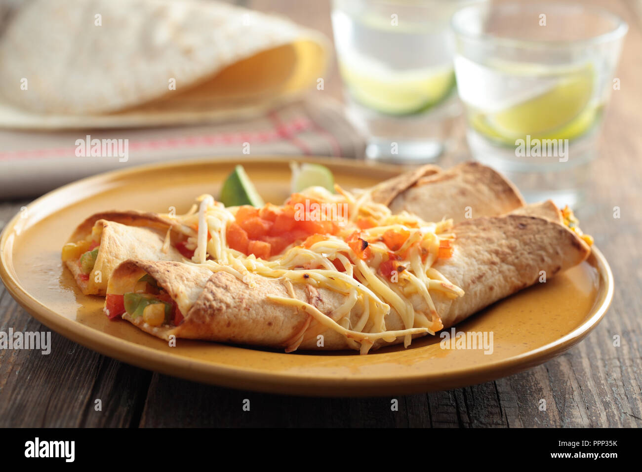 Two enchiladas on a rustic table Stock Photo
