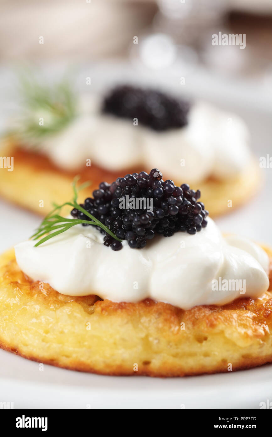 Blinis with black caviar and sour cream Stock Photo
