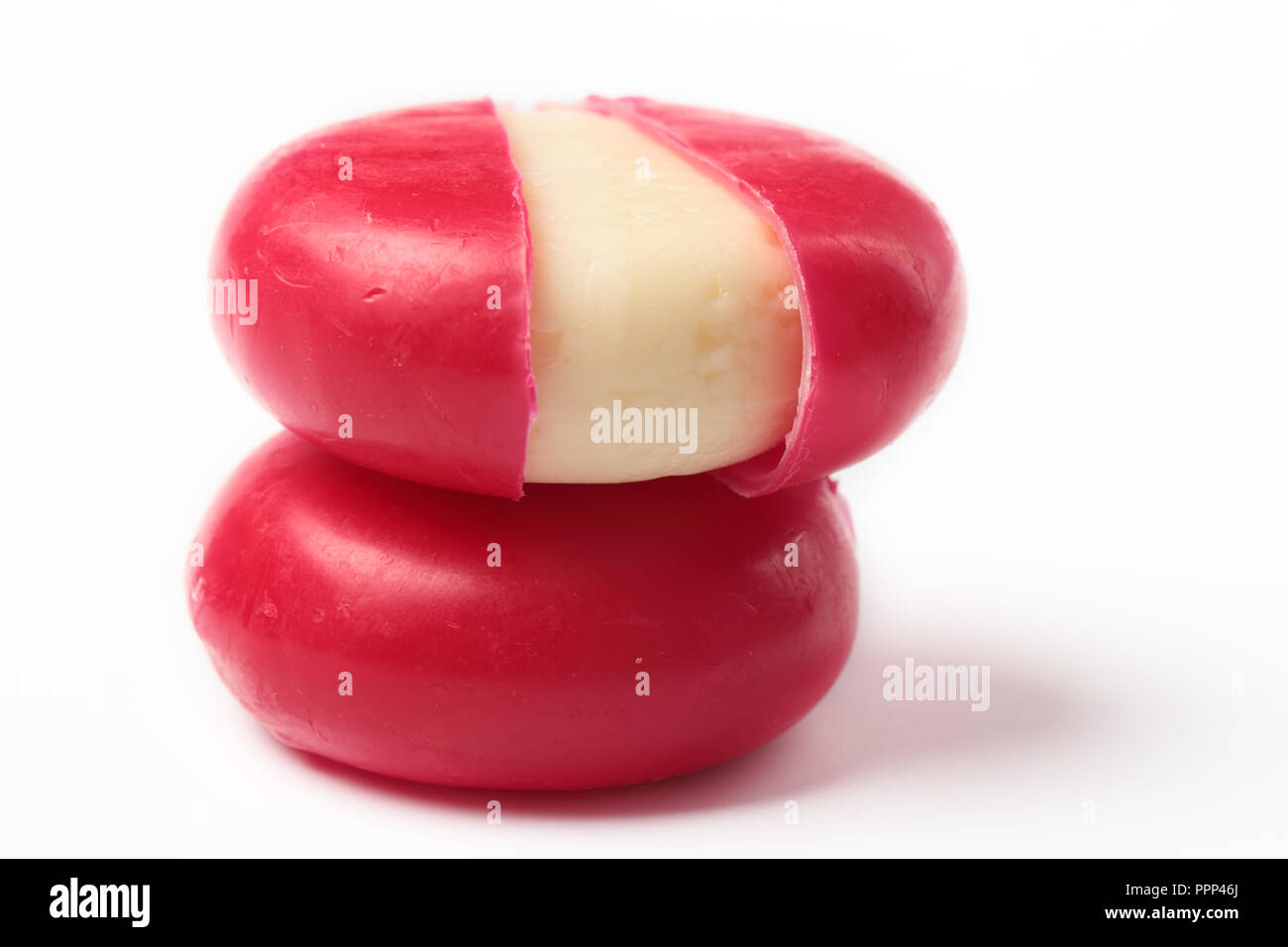 Two piece of cheese in red wax against white background Stock Photo Alamy