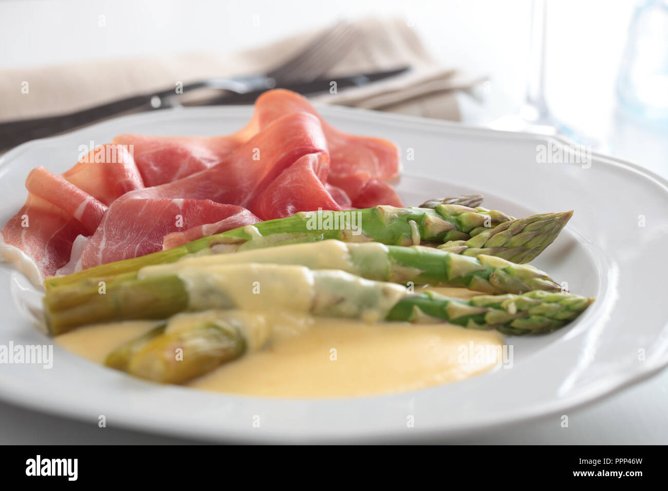 Prosciutto with steamed asparagus under cheese sauce Stock Photo