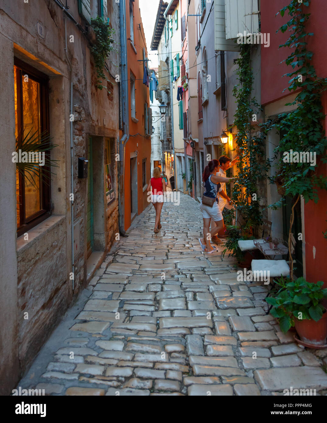 Alley at dusk in Rovinj with couple walking Stock Photo
