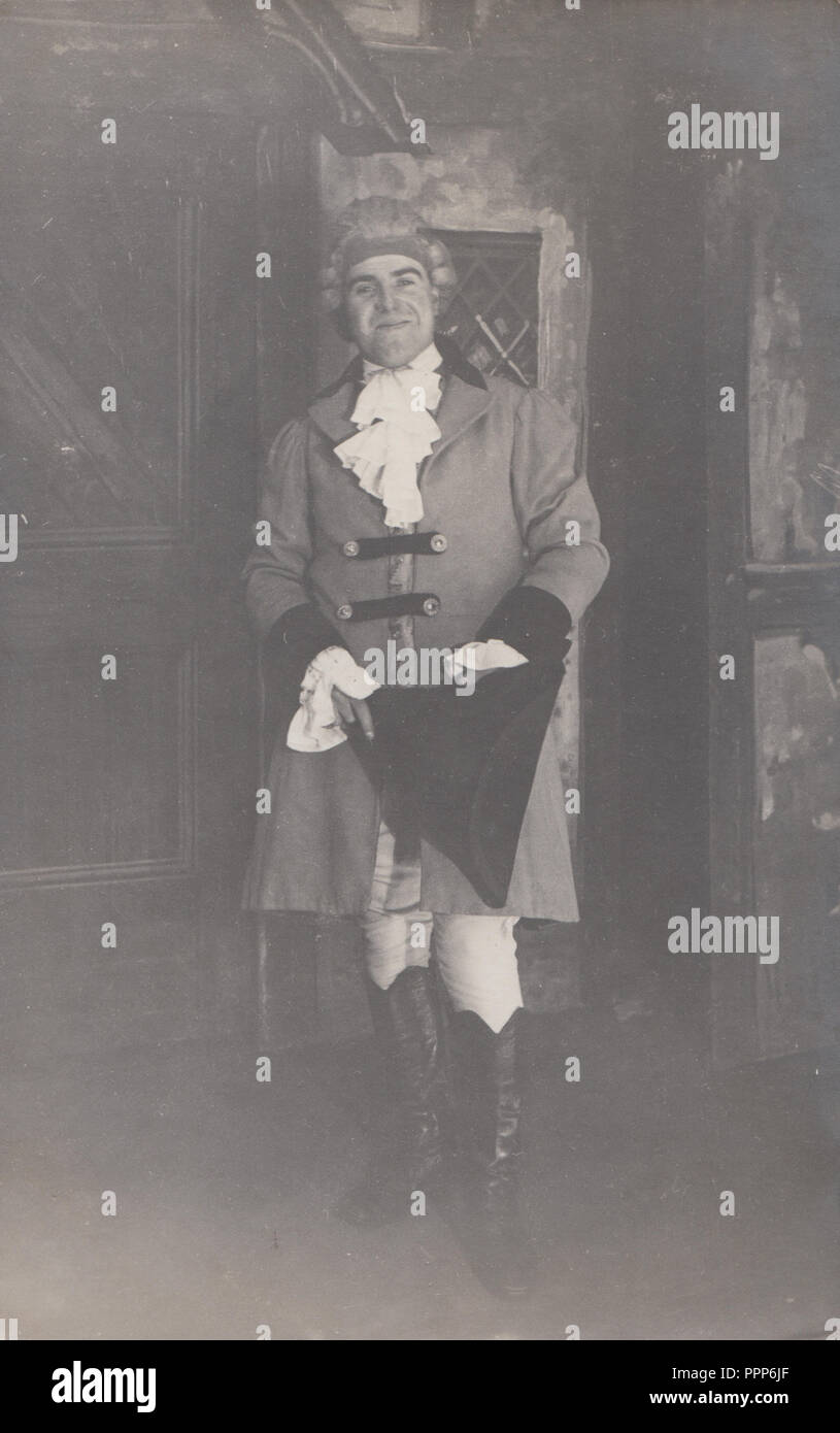 Vintage Photographic Postcard of a Man Wearing a Colonial Type Costume Holding a Tricorn Hat Stock Photo