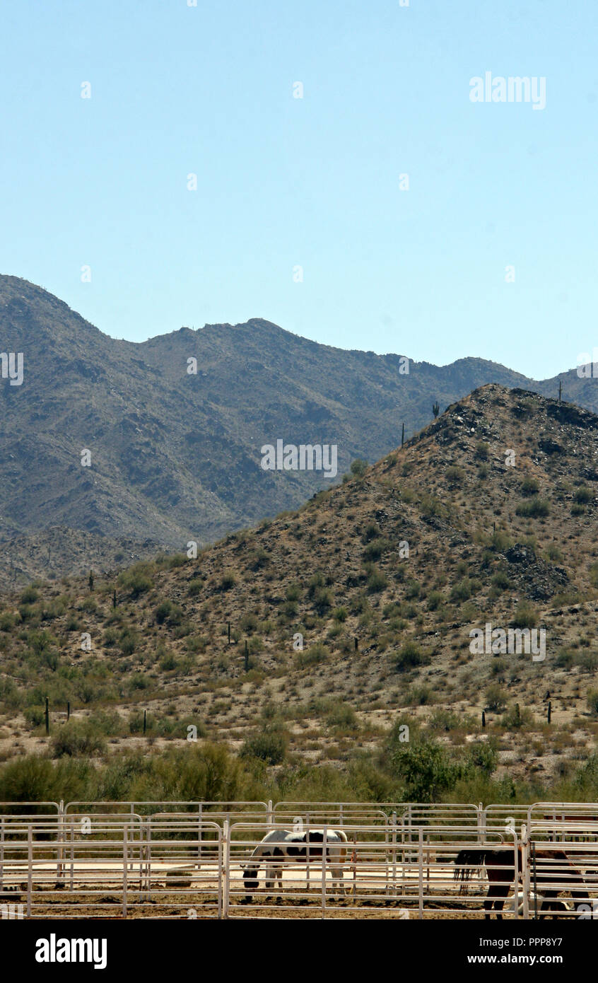 Blue Arizona Sky mountains and stock horse corrals at base Stock Photo