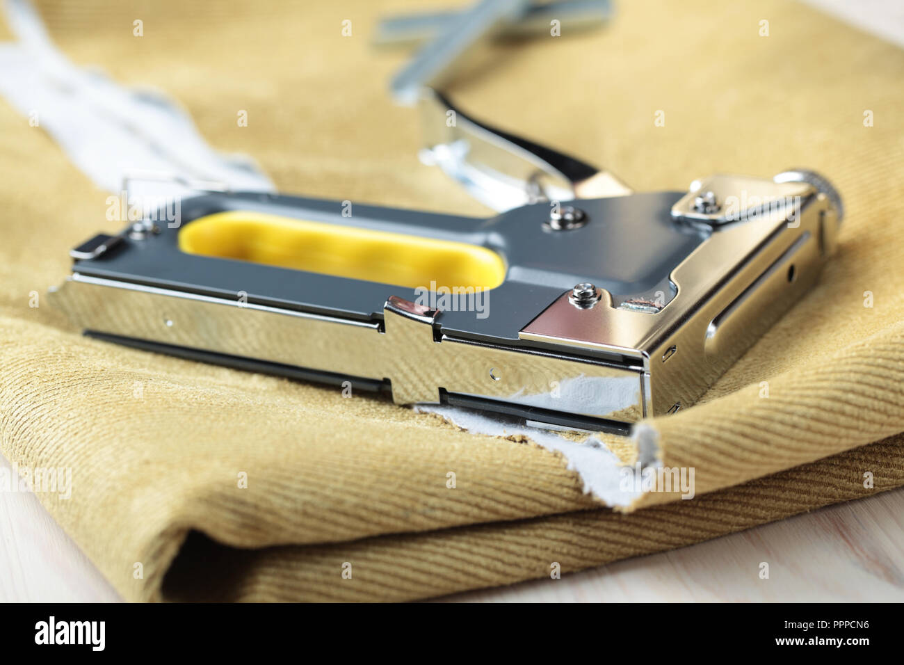 Upholstery stapler on a piece of fabric Stock Photo Alamy