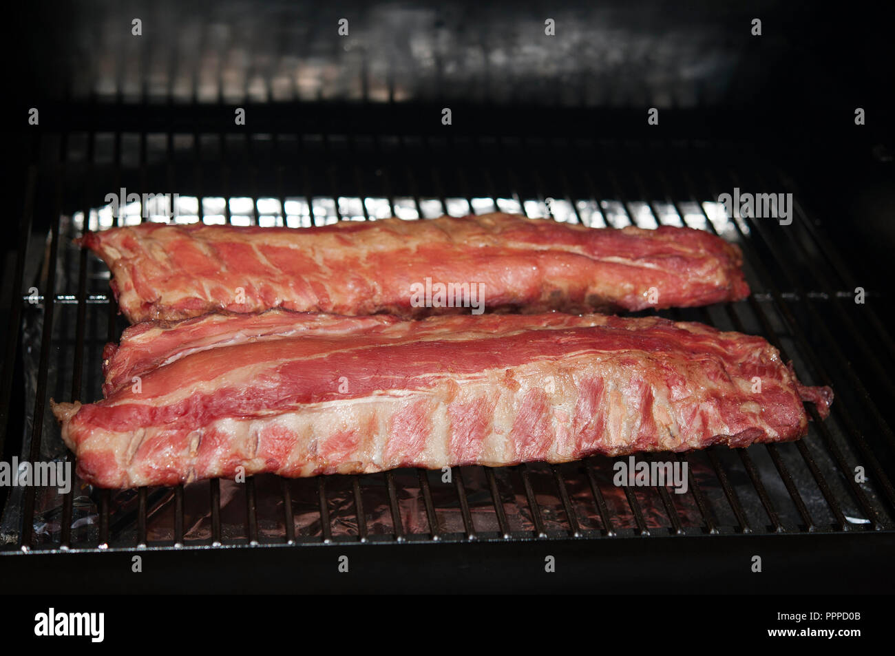 Racks of pork ribs cooking on the barbque Stock Photo Alamy