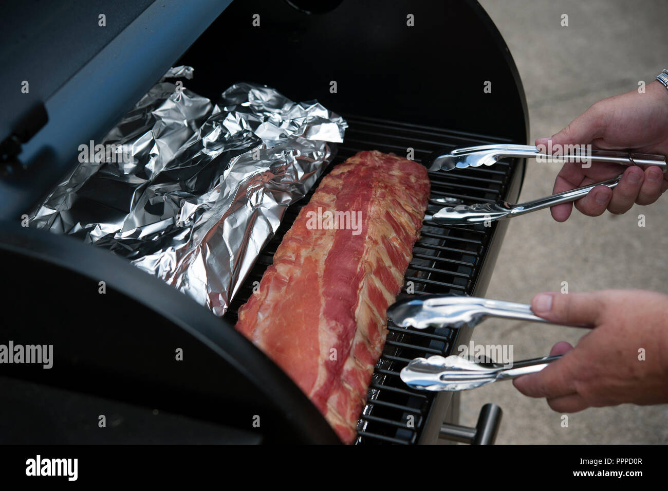 Racks of pork ribs cooking on the barbque Stock Photo Alamy