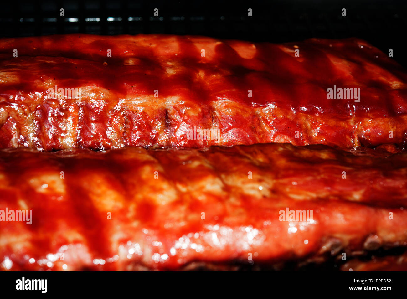 Racks of pork ribs cooking on the barbque Stock Photo Alamy