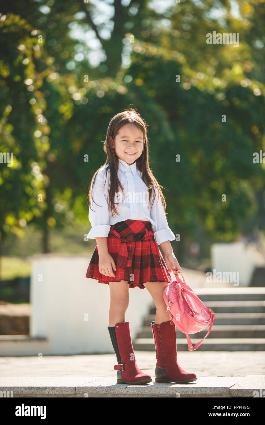 Beautiful little girl with backpack walking in the park ready back to ...