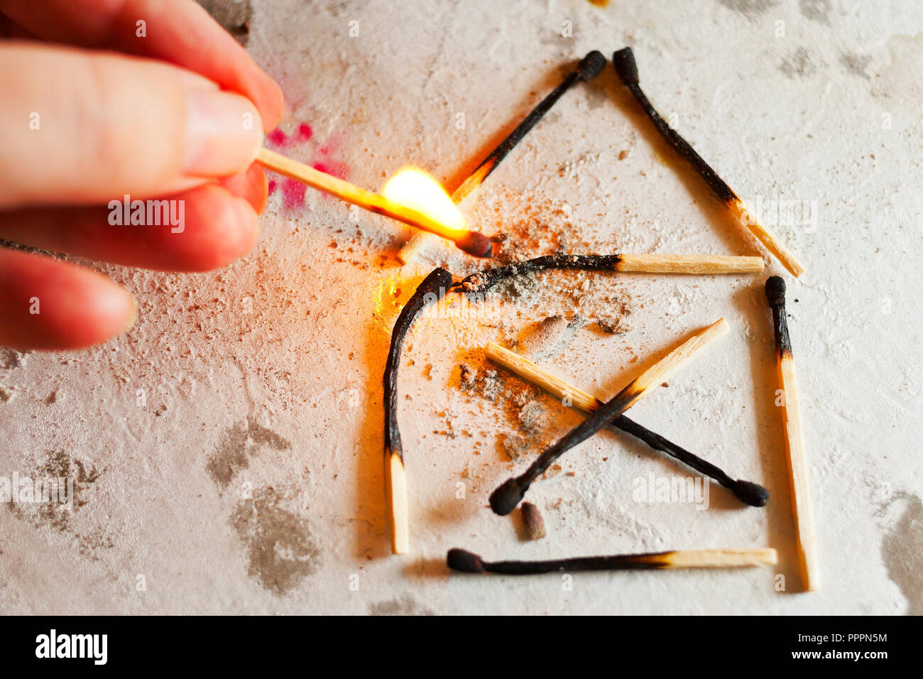 burnt out family house after fire made of used matches - safety first - security concept Stock Photo