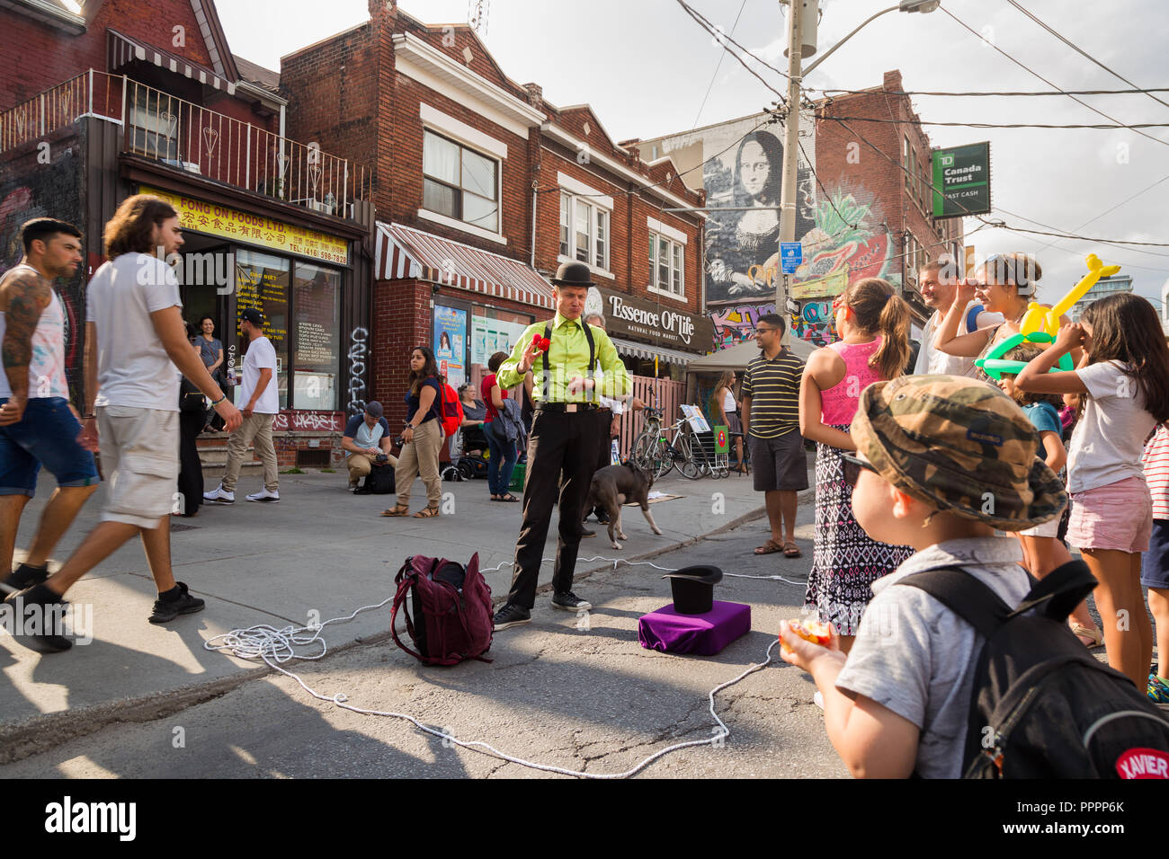 TORONTO, ON, CANADA - JULY 29, 2018: A child watches a street performer at Kensington market in Toronto. Stock Photo