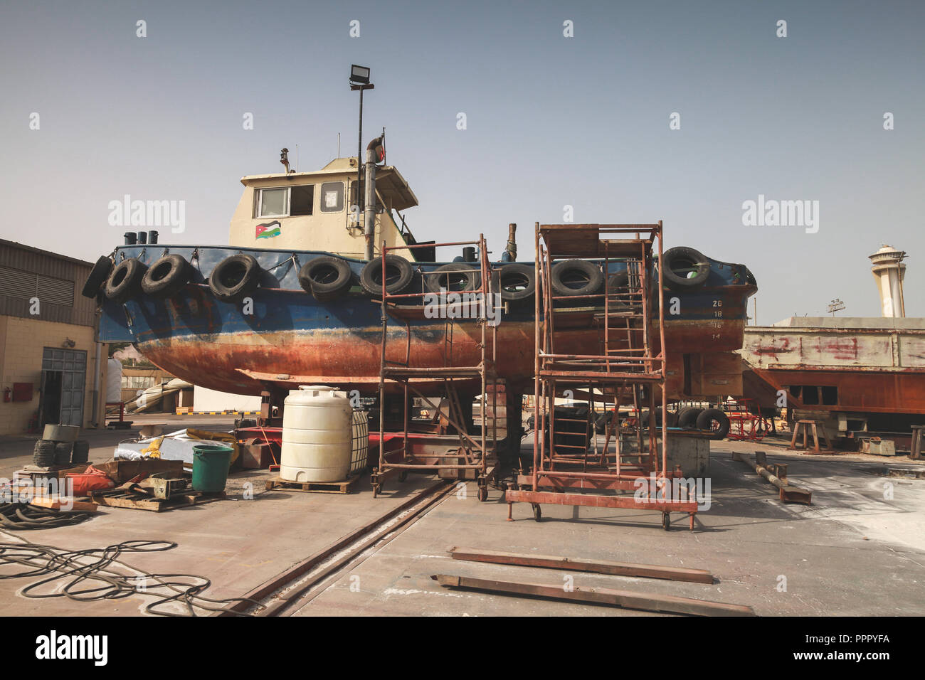 Old tugboat for repair at dock, Aqaba port Stock Photo
