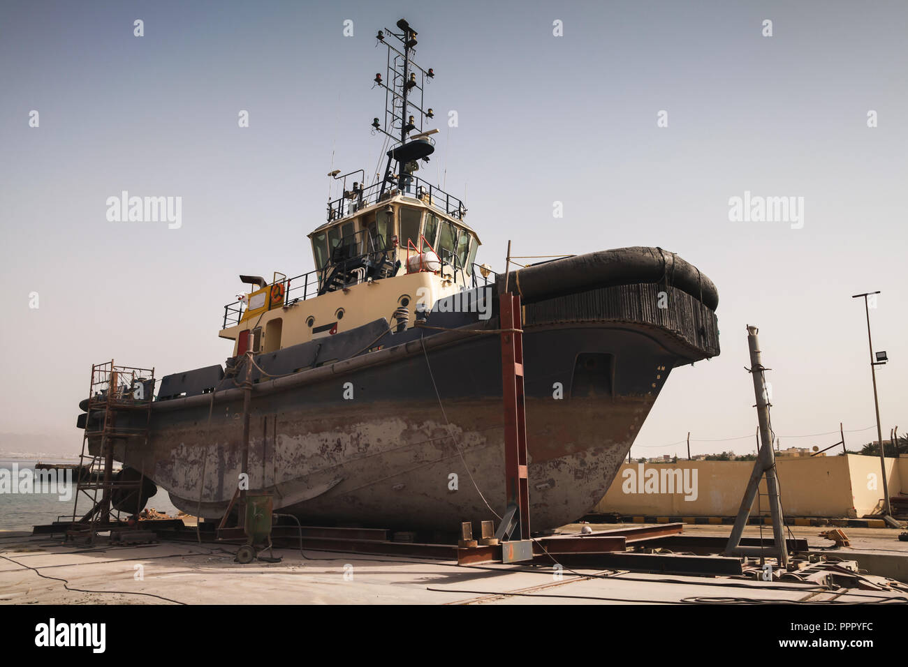 Old tugboat for repair at dock, Aqaba port, Jordan Stock Photo