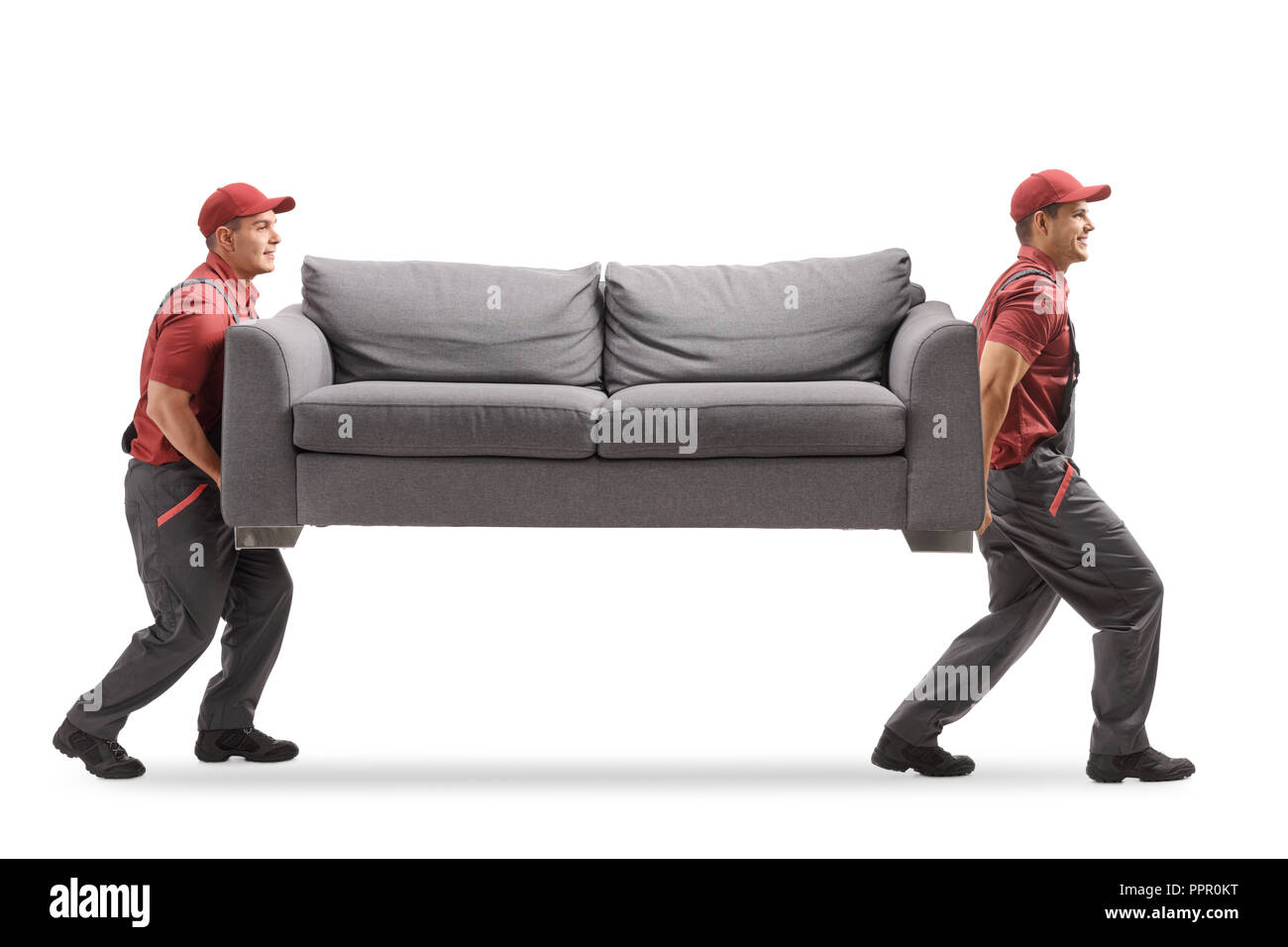 Full Length Profile Shot Of Two Movers Carrying A Couch Isolated