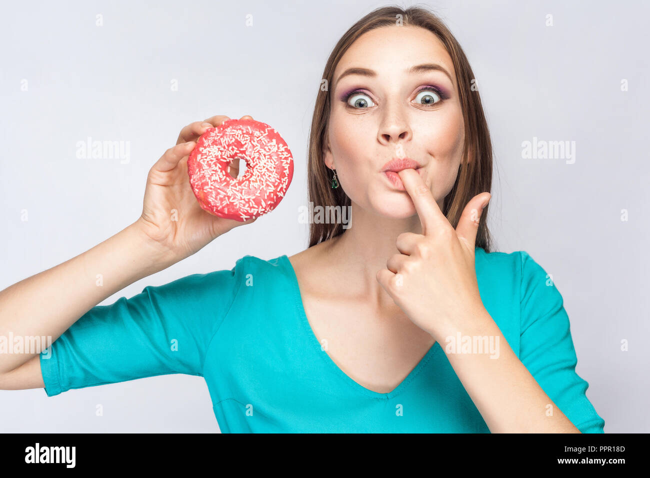 Portrait Of Crazy Young Beautiful Girl In Blue Blouse Standing Holding And Showing Pink Donut 