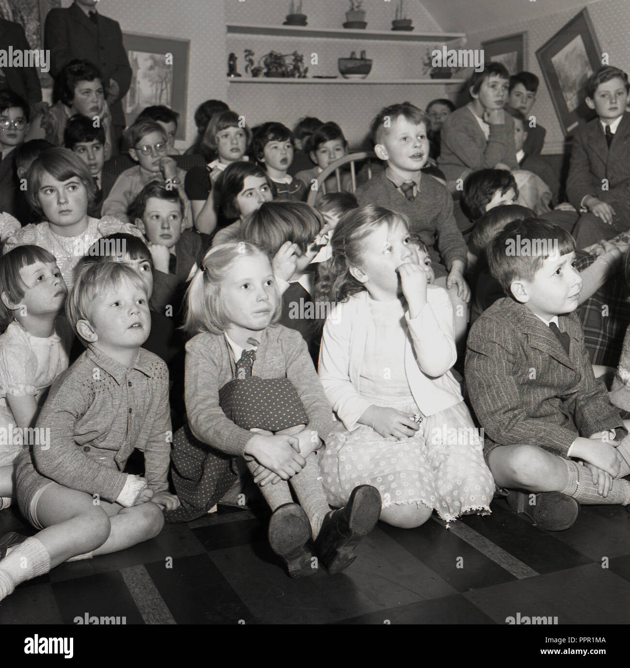 1950s, historical, group of primary schoolchildren sitting together on ...