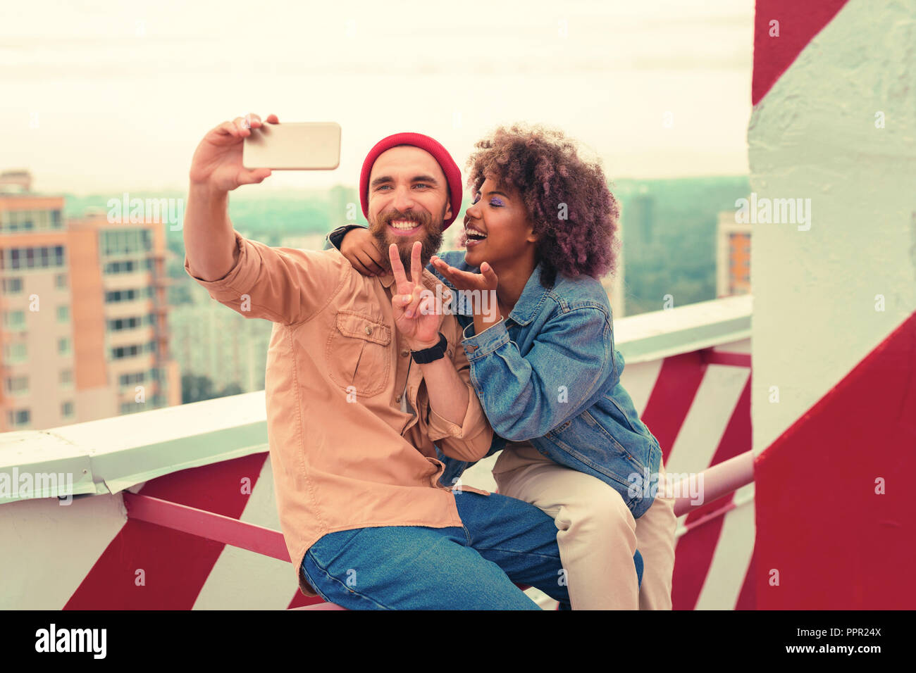 Funny young couple making ridiculous faces while taking selfies together Stock Photo