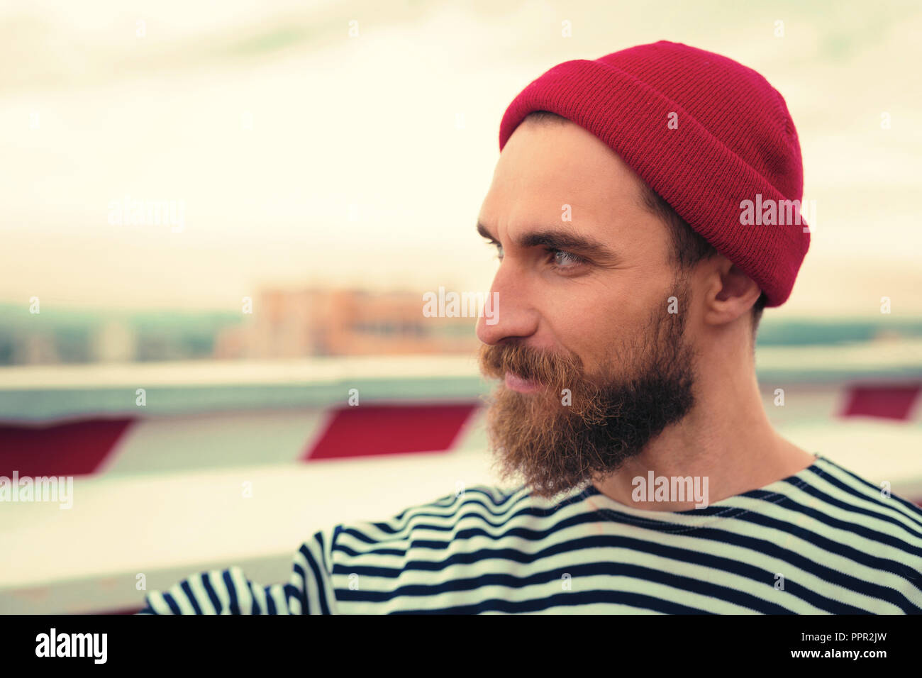 Confident bearded man smiling while looking into the distance Stock Photo