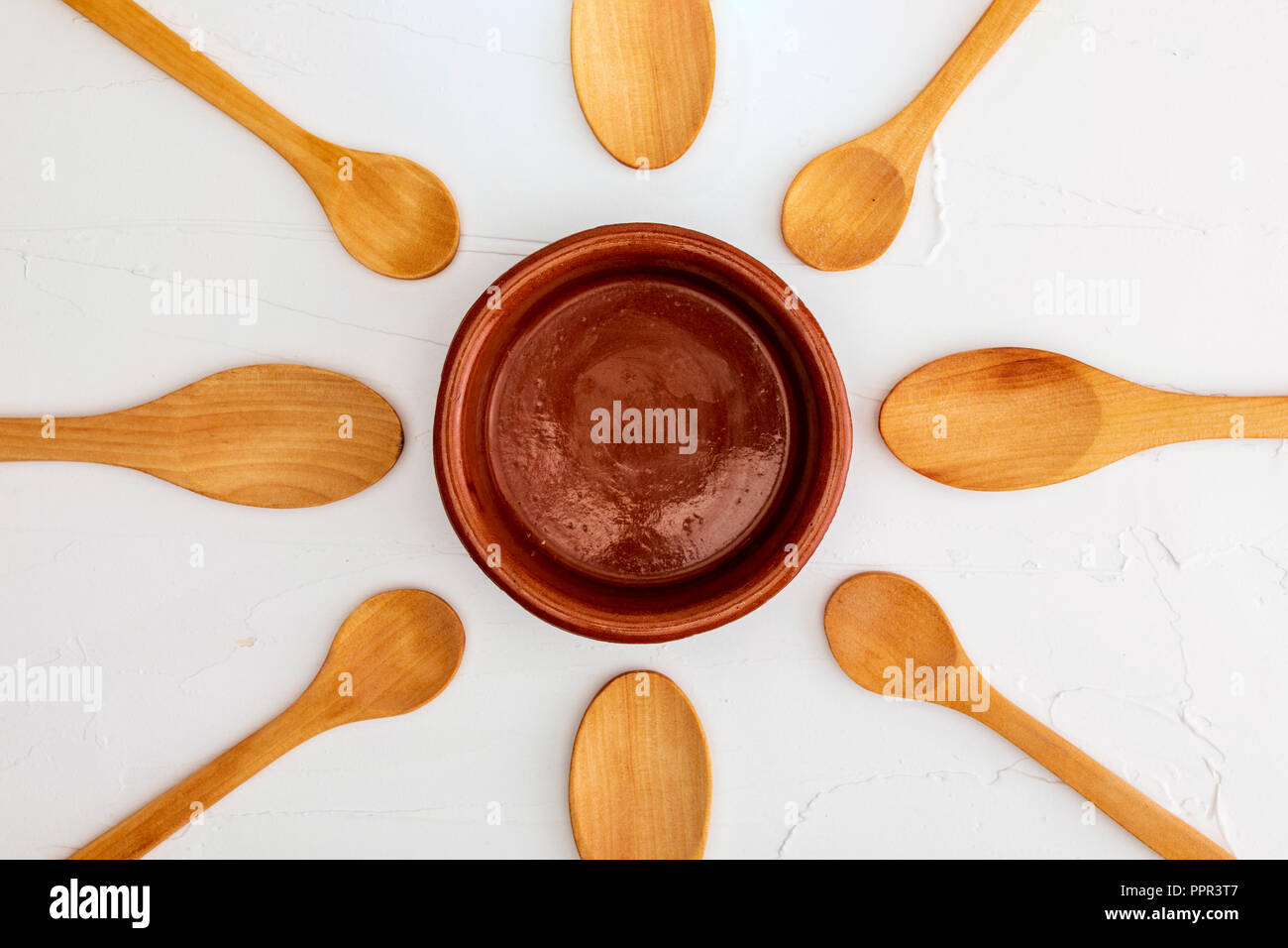 Crockpot and wooden spoons on white background with texture. Space to ...