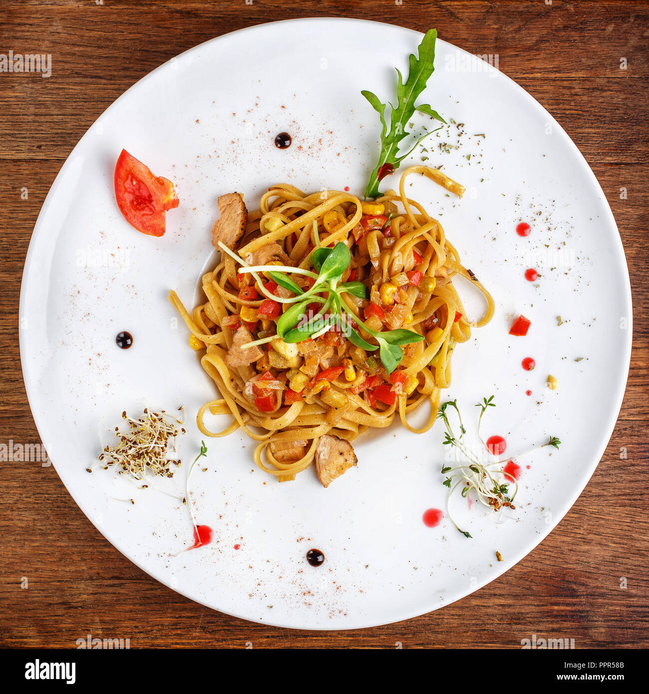 Delicious dishes from the chef. Ready made pasta with slices of meat, pepper and greens Stock Photo
