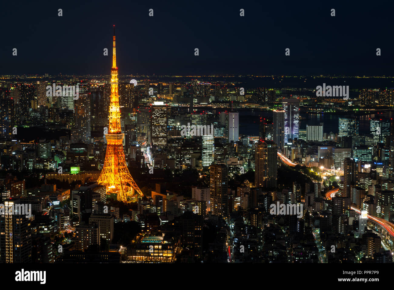Cityscape of Tokyo at night, as seen from the top of one of the highest buildings in Roppongi Hills, with the illuminated Tokyo Tower glowing. Stock Photo