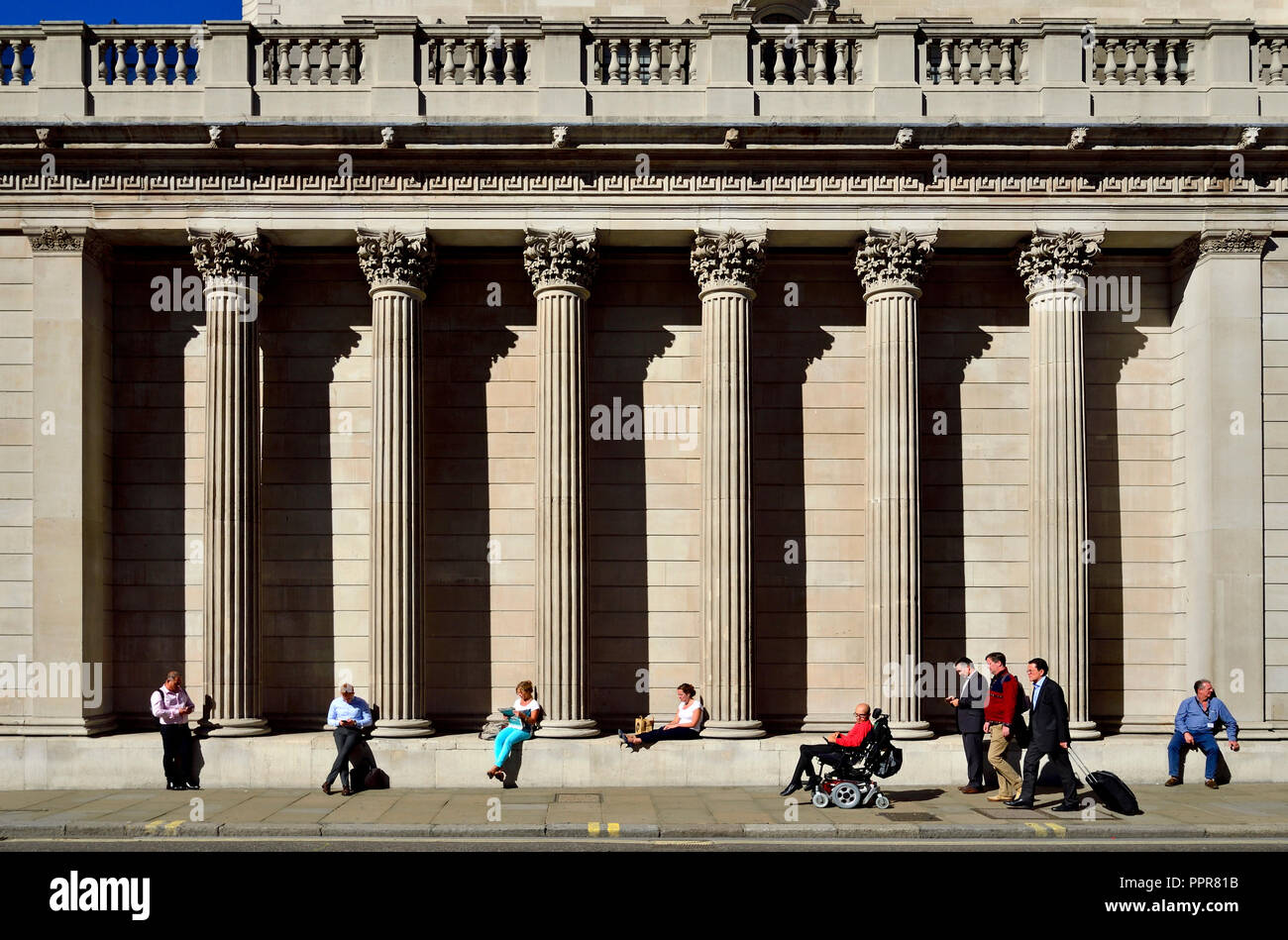 People sitting on the southern facade of the Bank of England, London, England, UK. Stock Photo