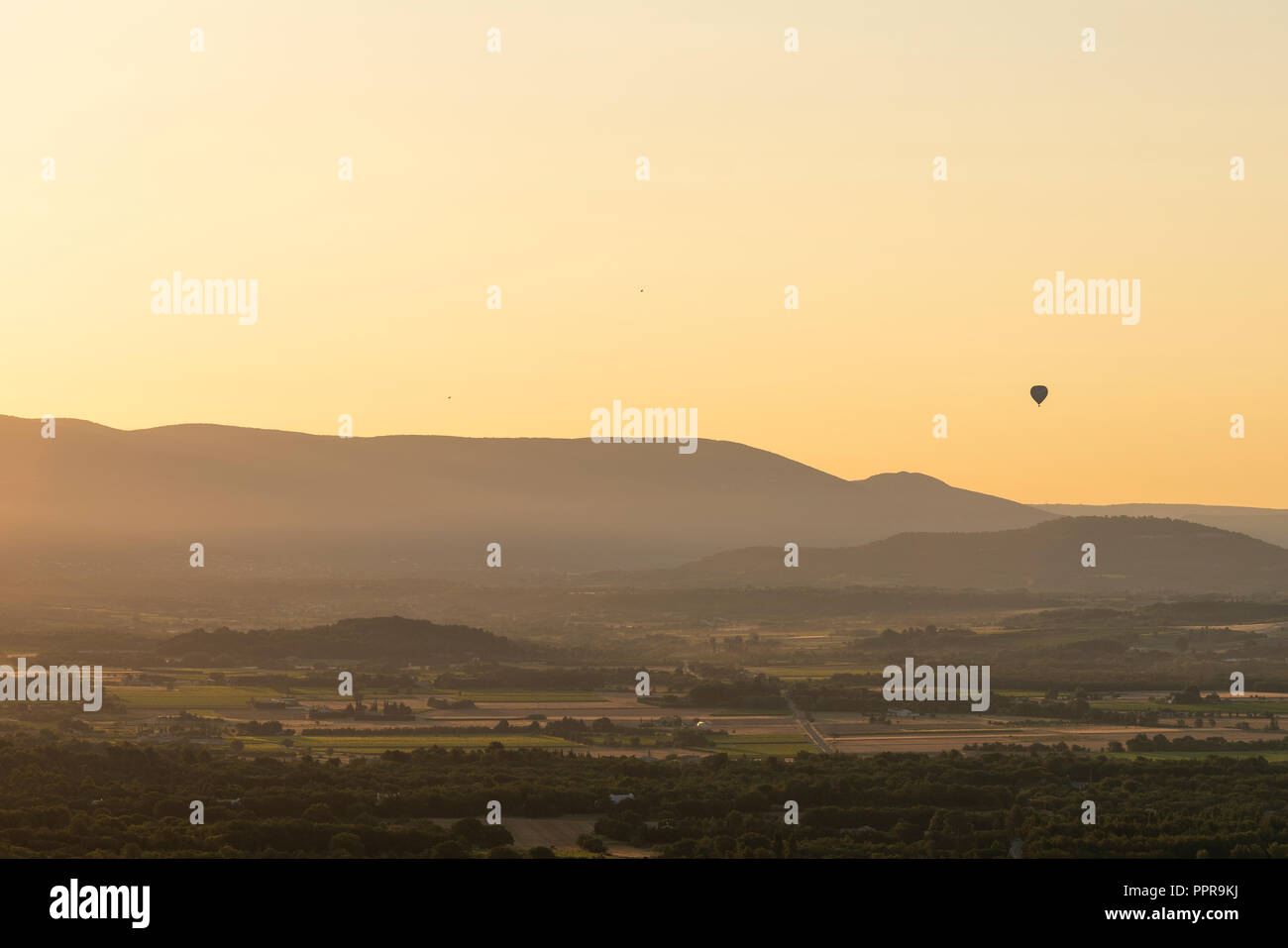 Hot-Air Balloon rising over French countryside at sunrise, Provence, France Stock Photo