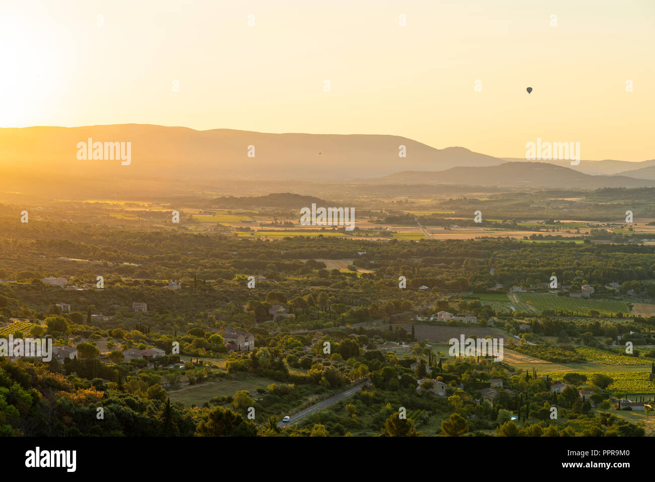 Hot-Air Balloon rising over French countryside at sunrise, Provence, France Stock Photo