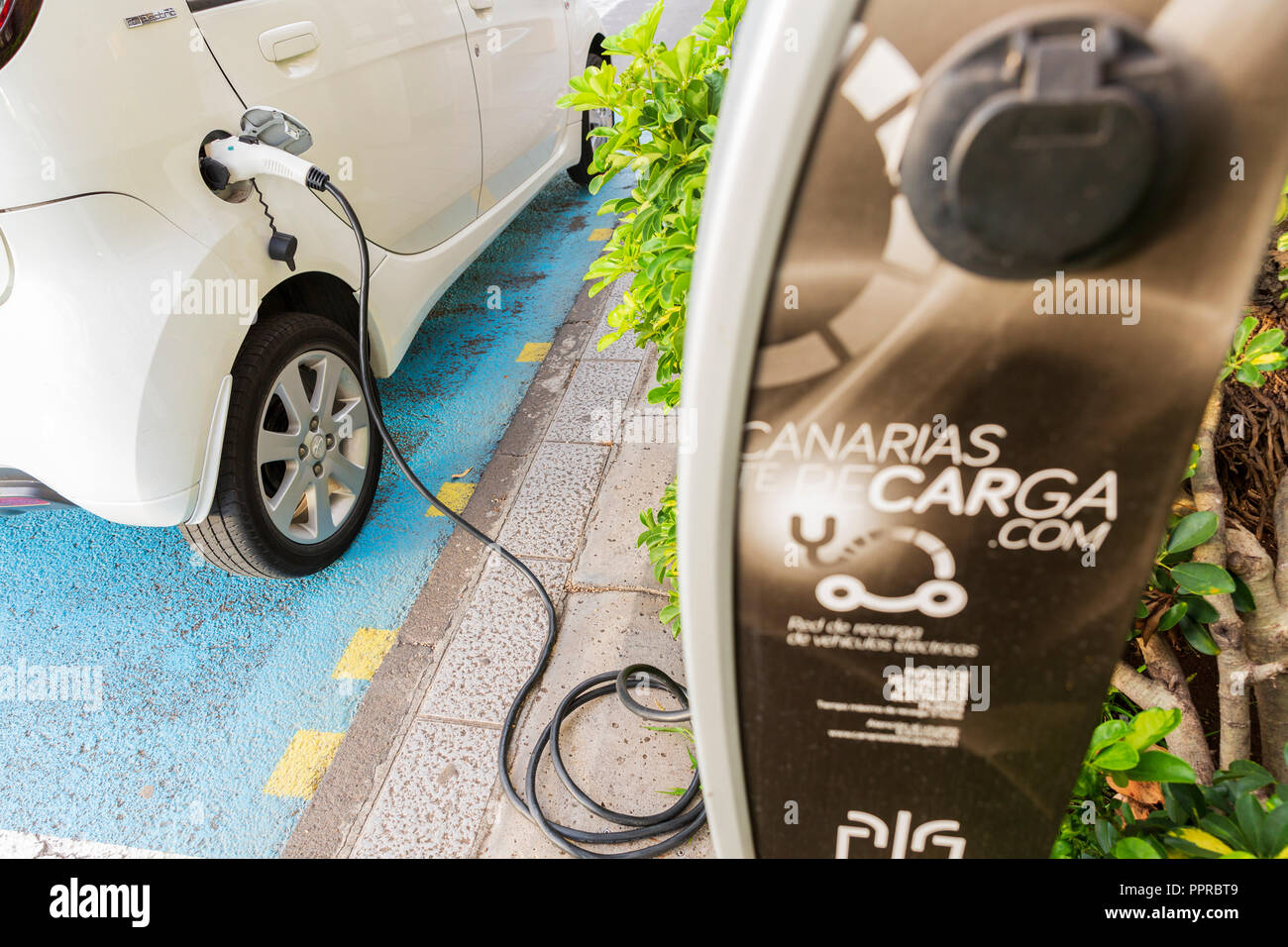 Peugeot Ion electric car plugged in at a public charching station on the street in Santa Cruz de La Palma, Canary Islands, Spain Stock Photo