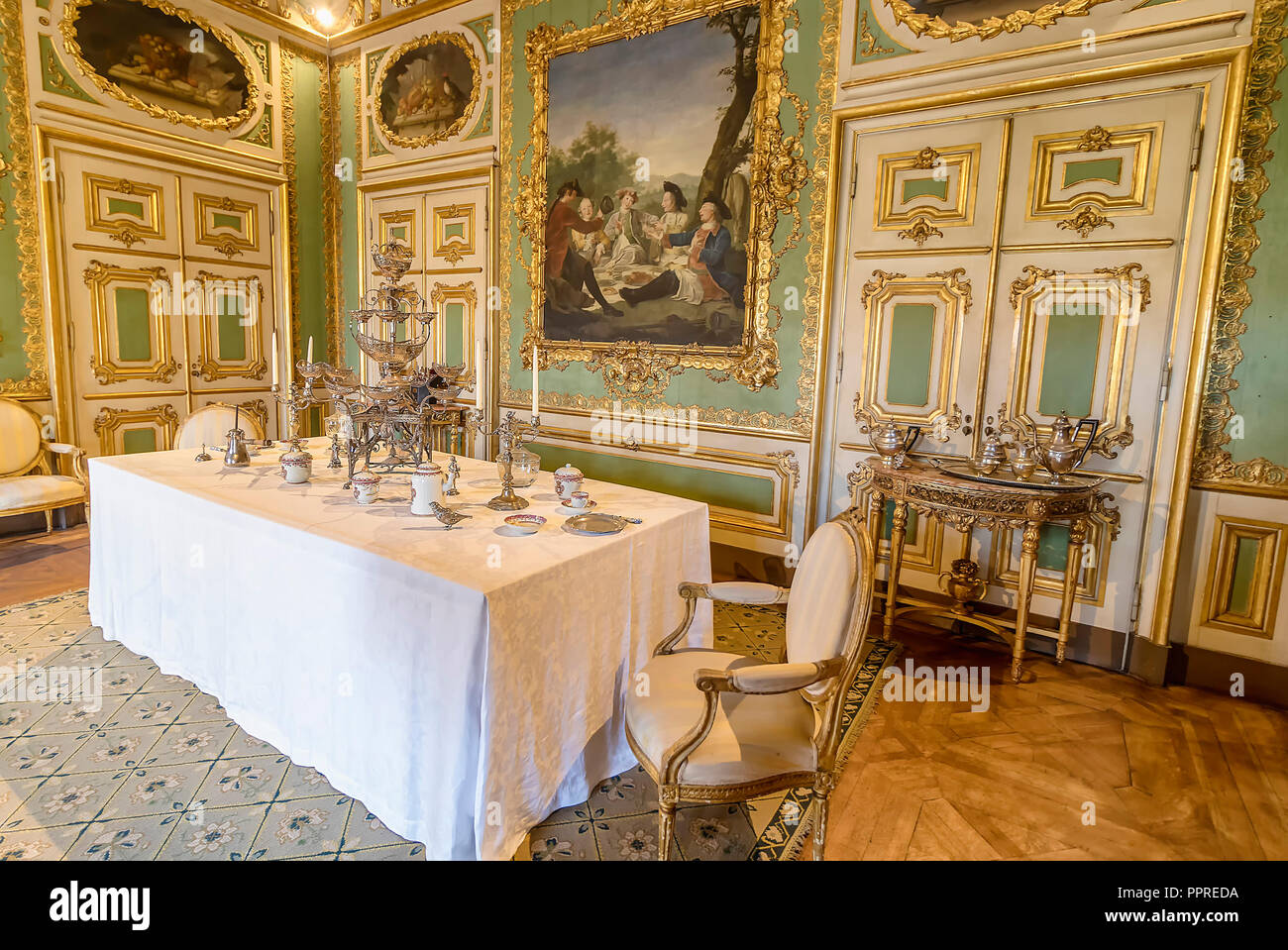 Queluz, Portugal - December 9, 2017: Vintage table setting with teacup inside of rich decorated Queluz Royal Palace. Formerly used as the Summer resid Stock Photo