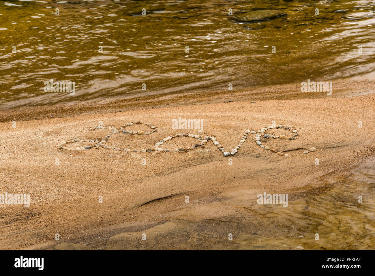 The word 'Love' written in stones on a sandy beach, White Mountain National Forest, NH Stock Photo
