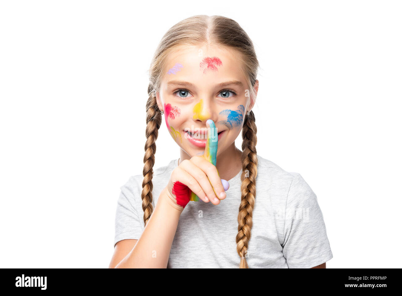 schoolchild with paints on face showing silence gesture isolated on white Stock Photo