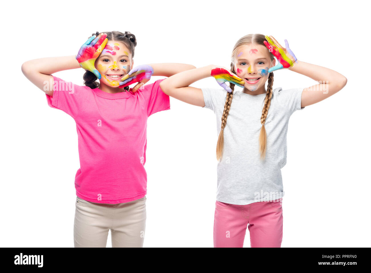schoolchildren touching faces with painted hands isolated on white Stock Photo