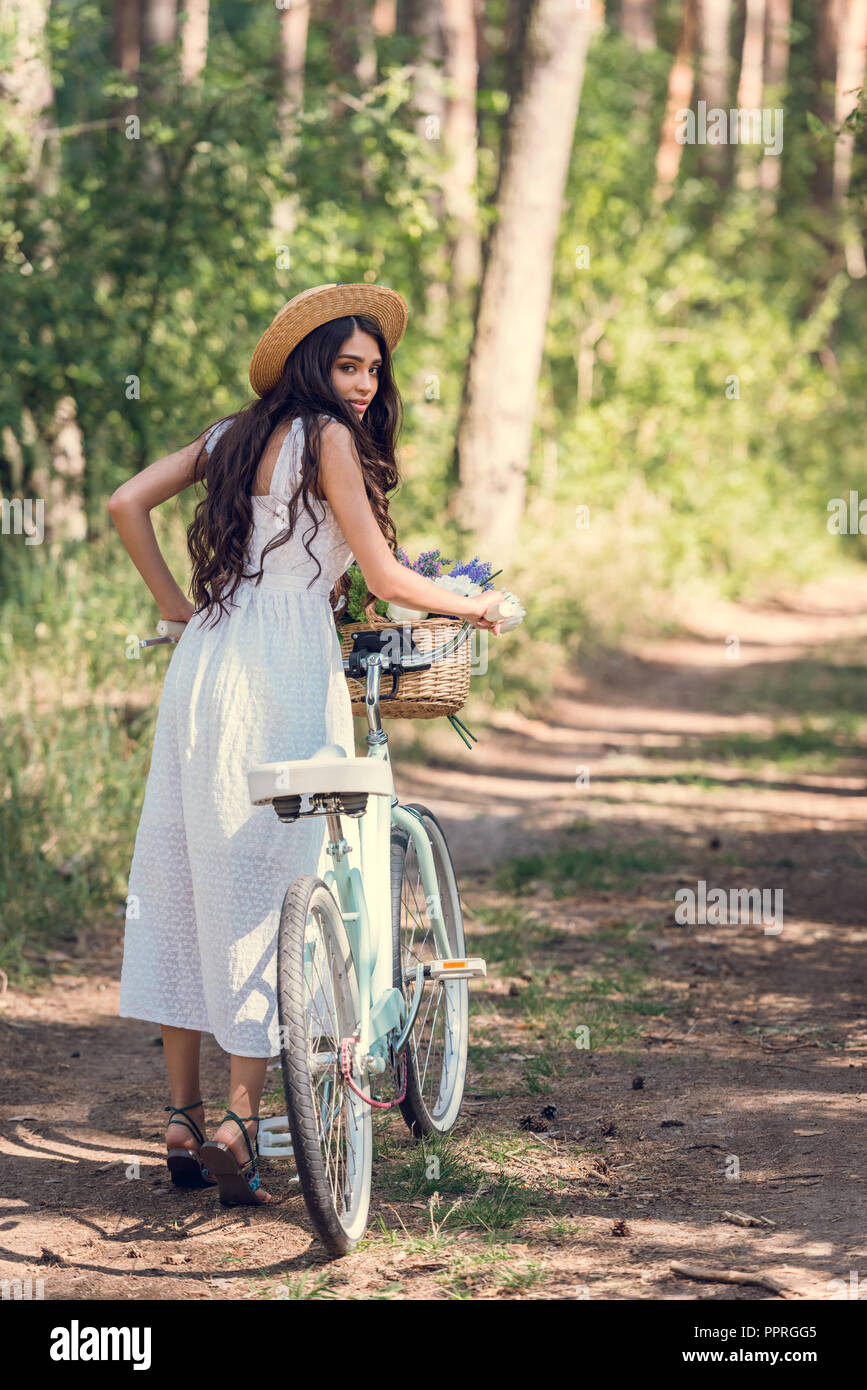straw hat and white dress walking 