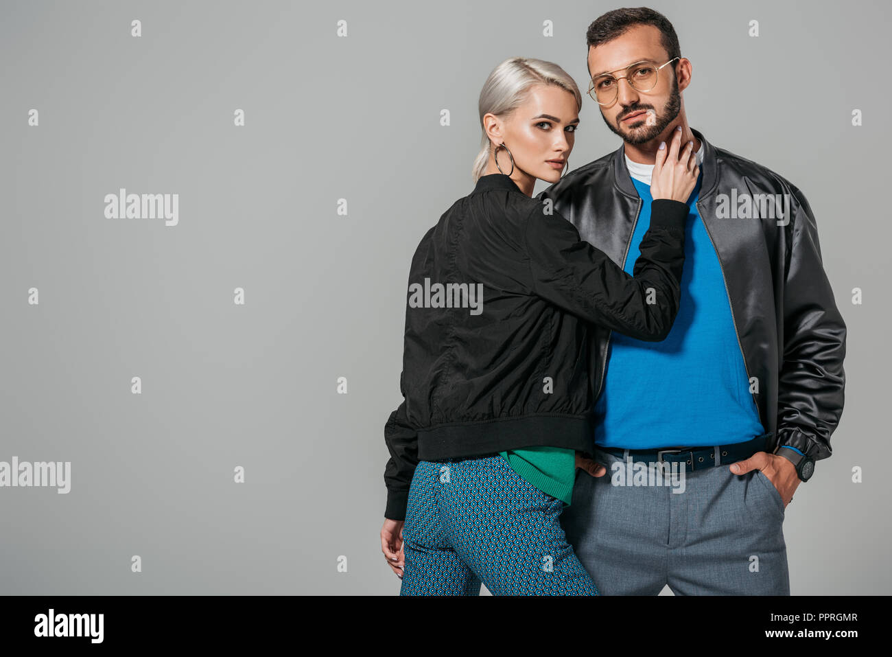 attractive young woman touching neck of stylish boyfriend isolated on ...