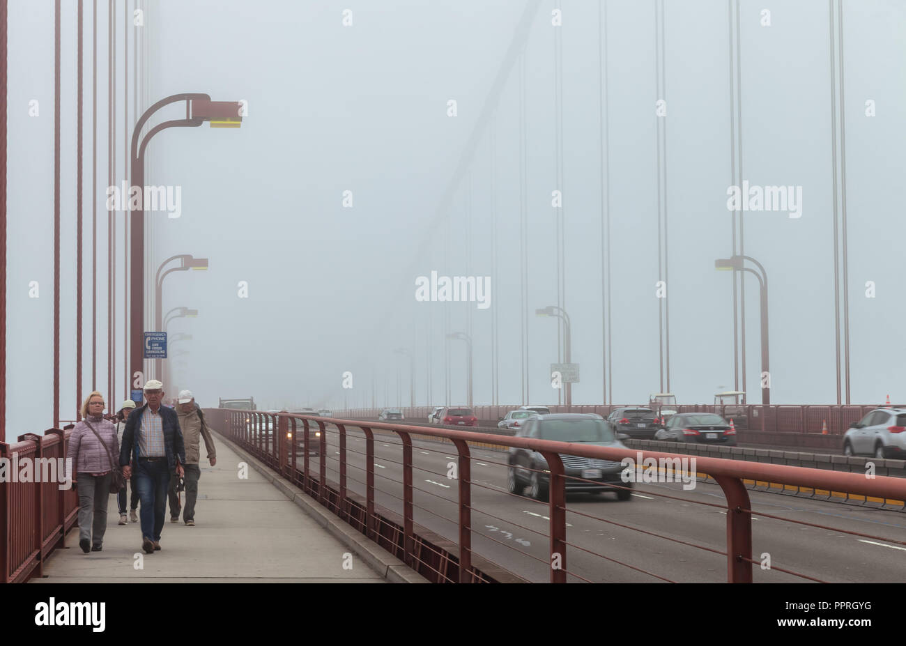 Pedestrians and traffic on the Golden Gate Bridge on a foggy morning ...