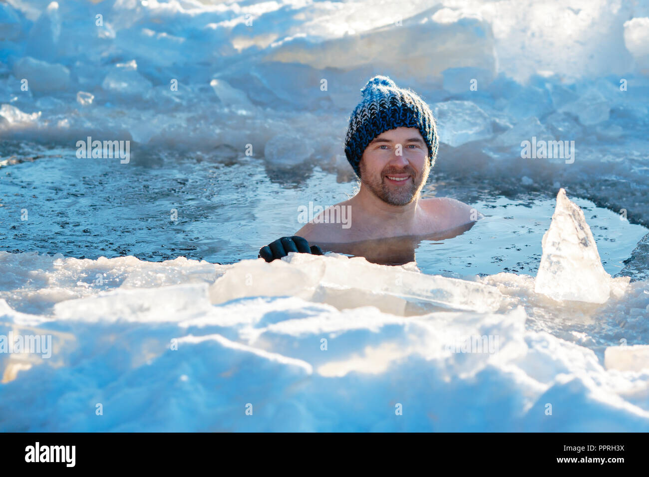 Winter swimming. Brave man in an ice-hole Stock Photo