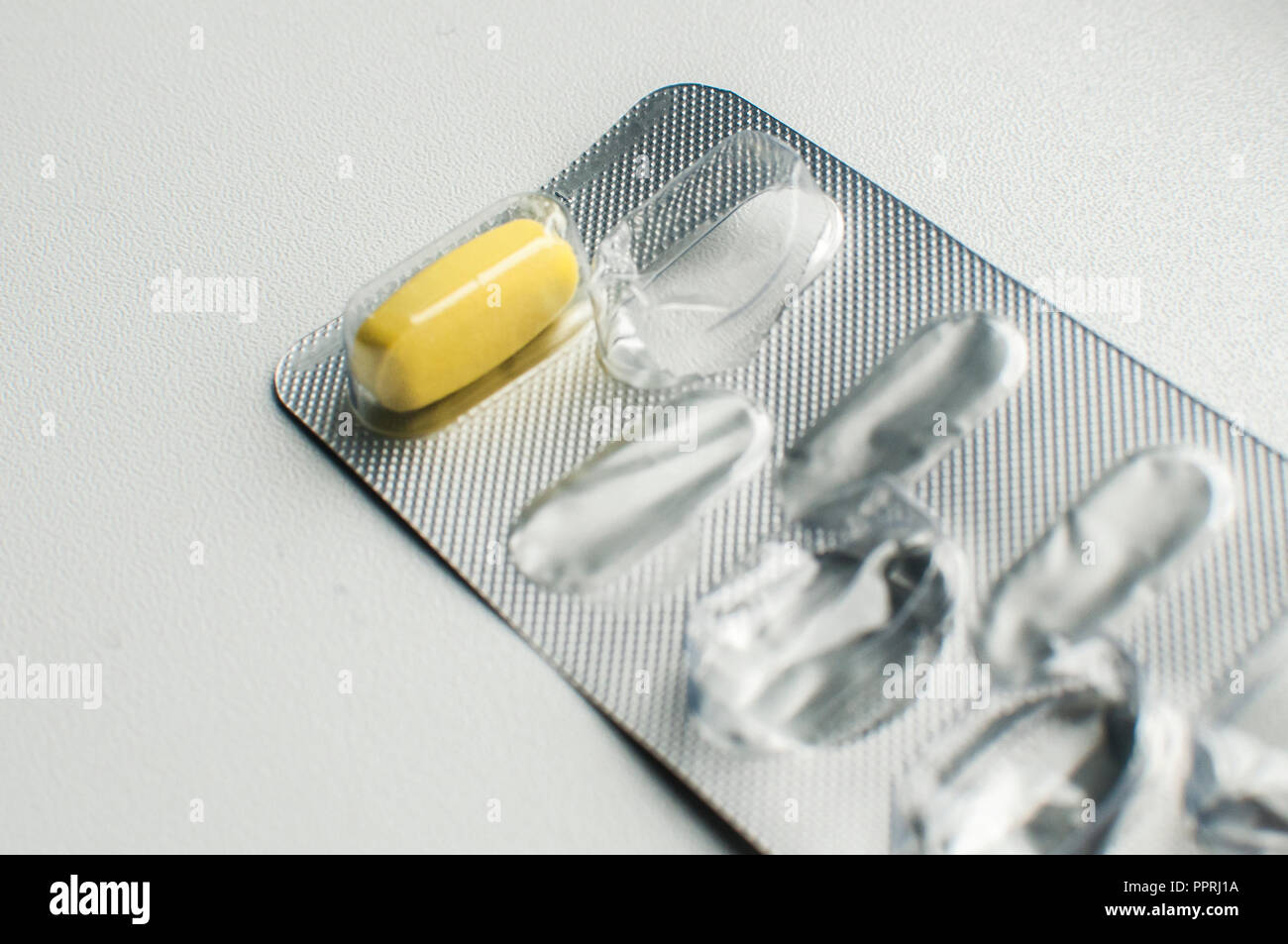 Empty Medication Packet One yellow pill left in used empty medicine blister pack closeup on ...