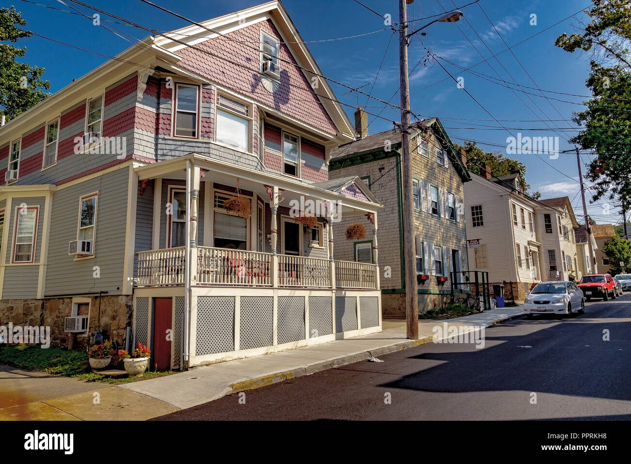 Wooden clap board house with front porch and veranda ,with pink and grey tile cladding on the upper level ,Howard St,Newport Rhode Island,USA Stock Photo