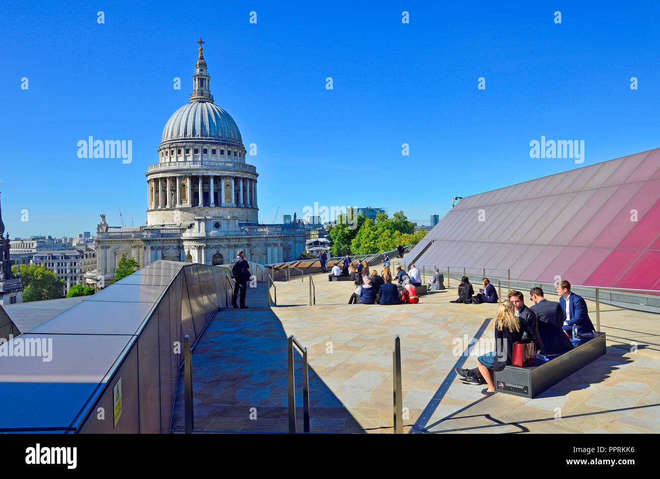 Office workers eating lunch on the roof of One New Change with a view of St Paul's Cathedral, London, England, UK. Stock Photo