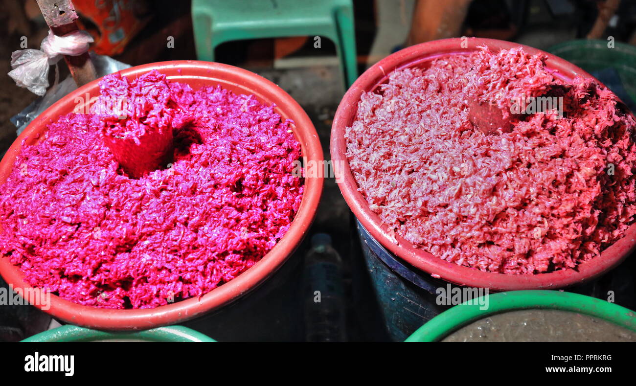 Plastic buckets filled with reddish-pinkish grated ube or purple yam. Used in various desserts and flavor for ice cream-milk-cookies-cakes-tarts-cupca Stock Photo