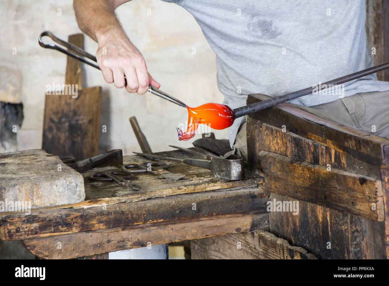 Glass worker makes glass sculptures in glass factory in Murano, Venice