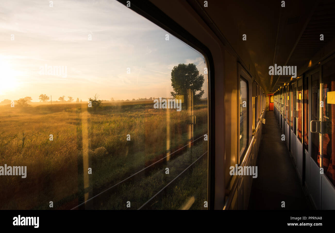 Beautiful sunrise on the vintage train in motion Stock Photo