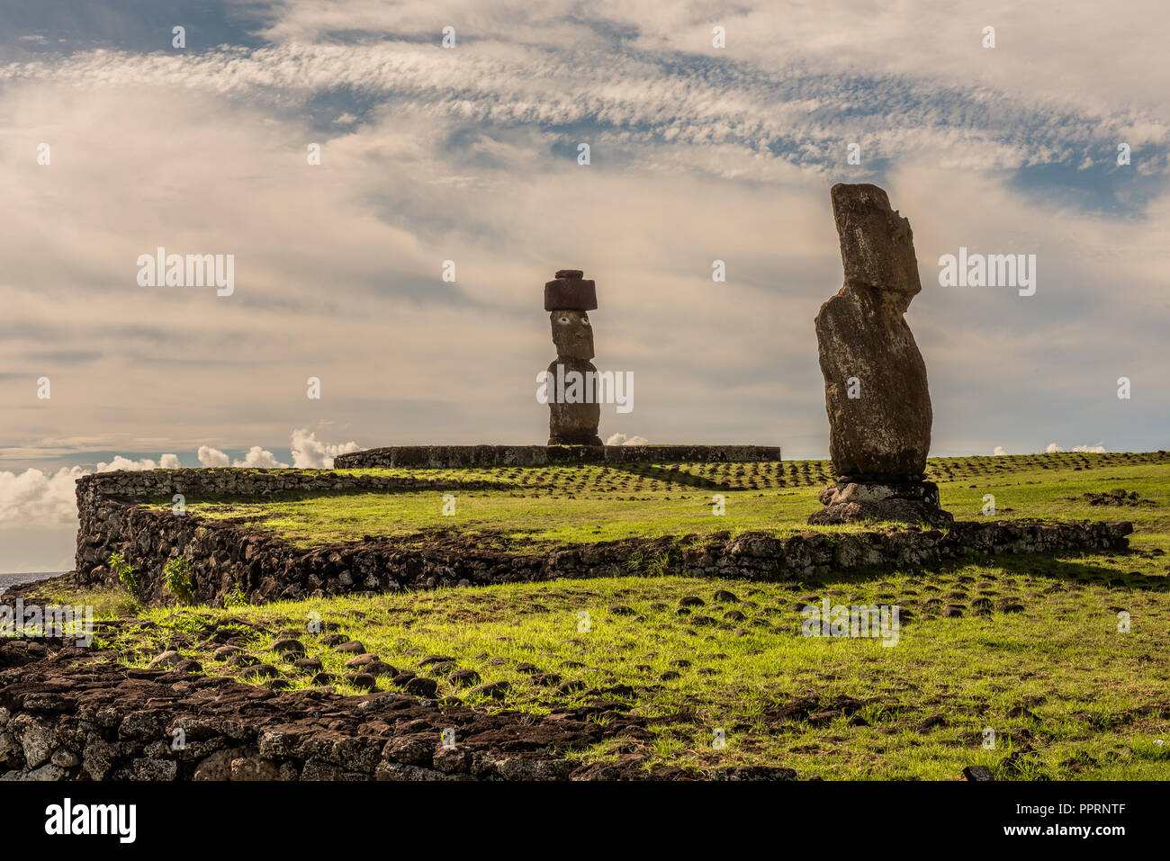 Two Moai statues on pedestals near an Easter Island beach face inward