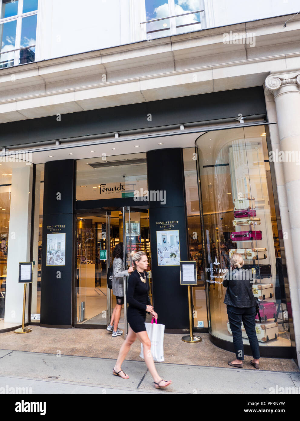 New Bond Street, London, UK. 18 June 2020. On a wet day some retailers  reopen for business in London's luxury shopping street with more traffic  and pedestrians around. Image: staff inside Louis
