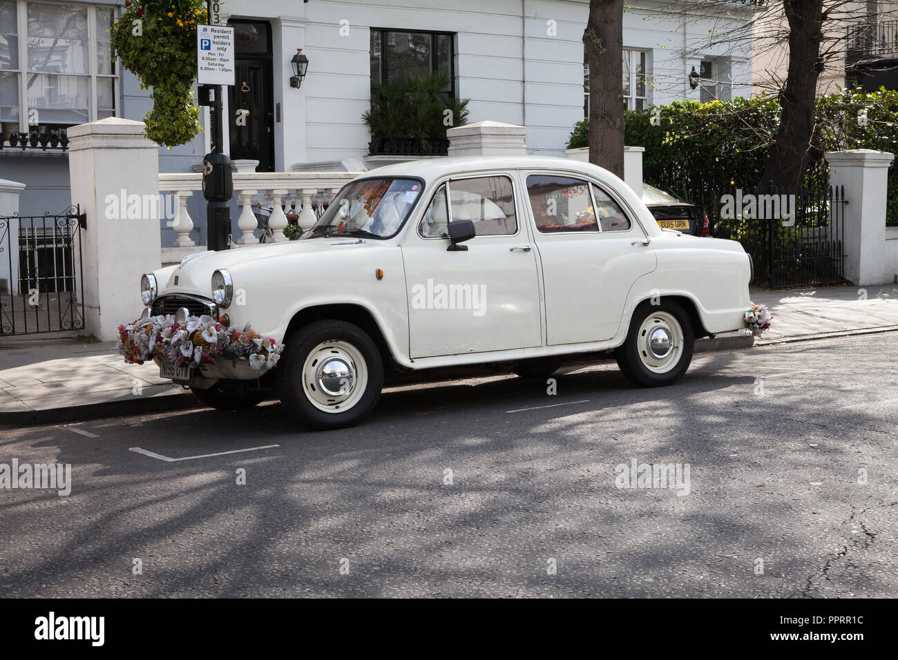 Ambassador car decorated with flowers parked in the Notting Hill area of London Stock Photo