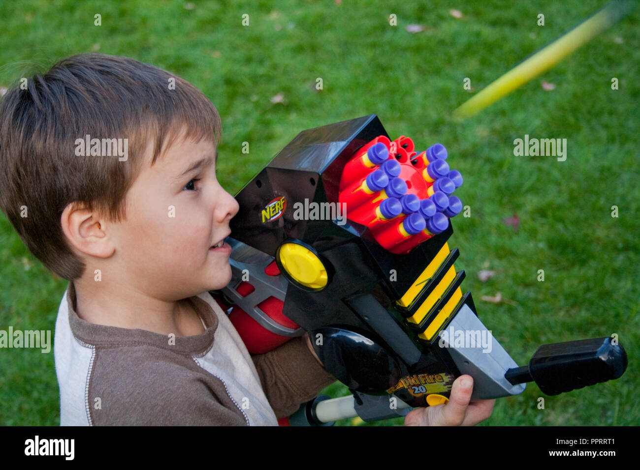Boy age 6 shooting his automatic Nerf Rapid Fire 20 toy machine gun. St Paul Minnesota MN USA Stock Photo