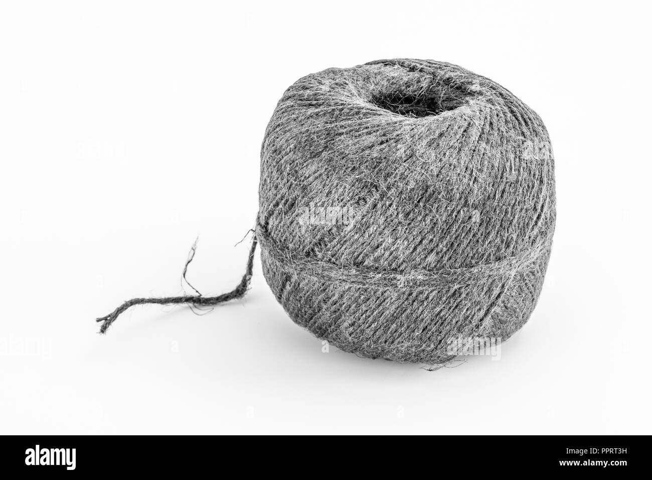 Natural tarred sisal garden twine / string. Grungy B&W conversion of PPRT3B. Metaphor 'How long is a piece of string.' Stock Photo