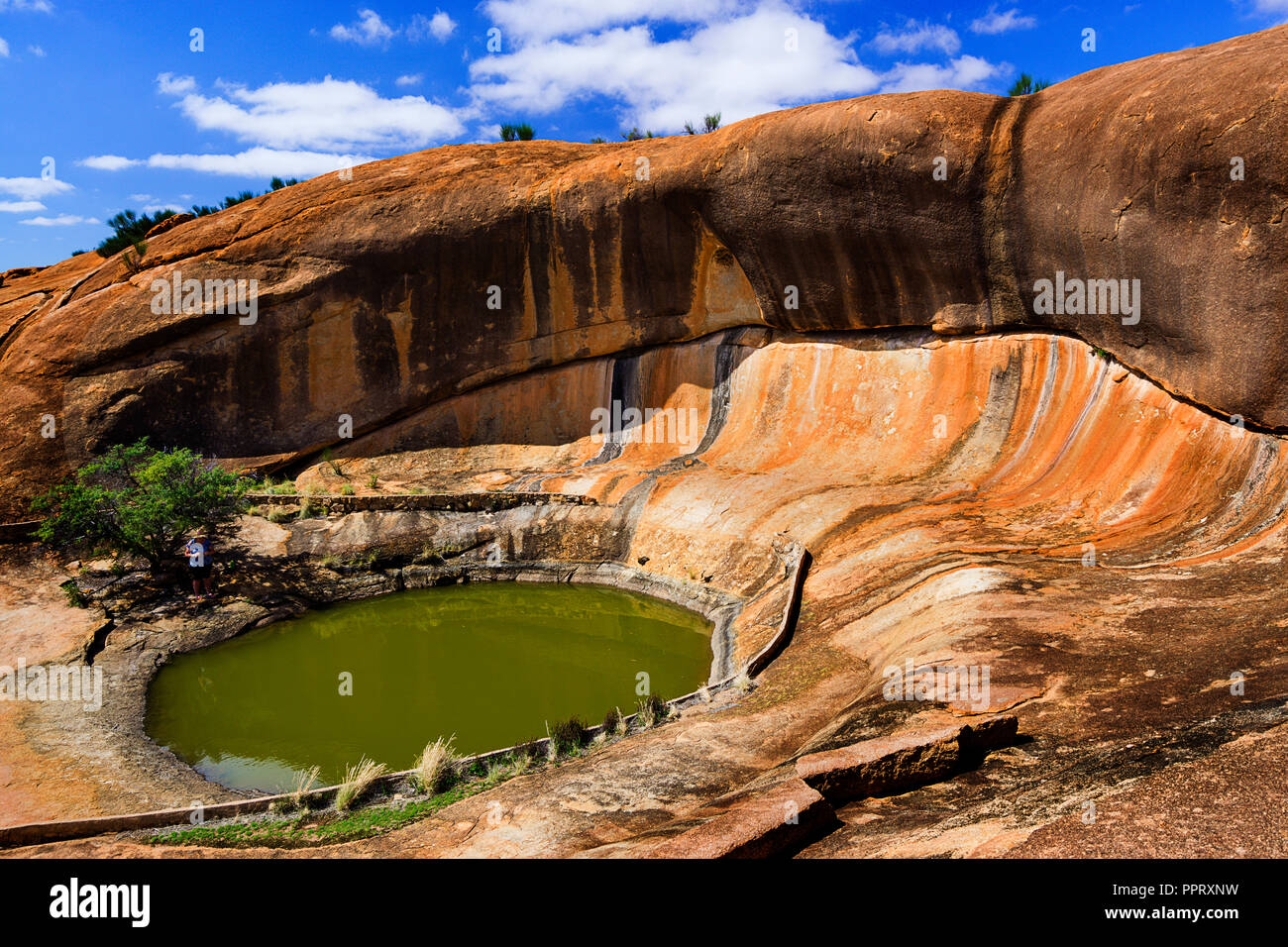 Waterhole also known as gnamma holes by the aboriginals and wave rock formation at Beringbooding Rock Western Australia Stock Photo