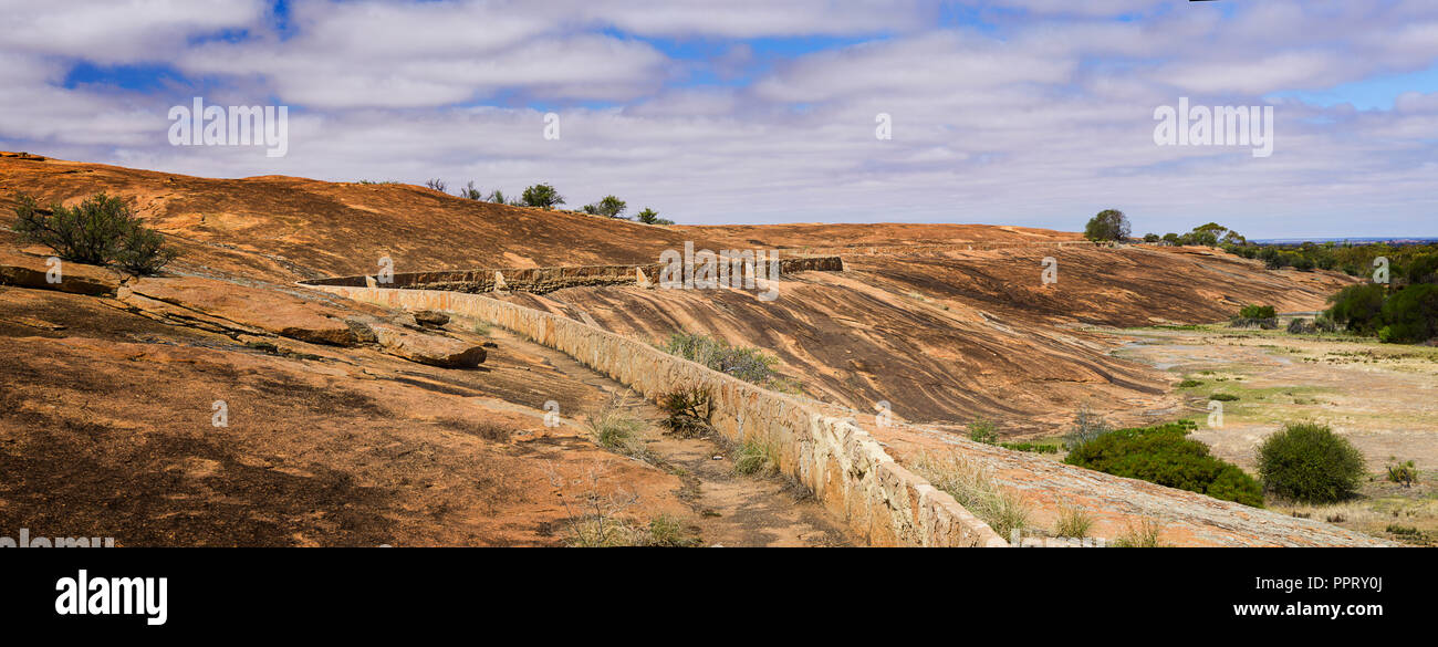 Rock wall built on slopes of  Beringbooding Rock Western Australia to direct rainwater into water catchment tank Stock Photo